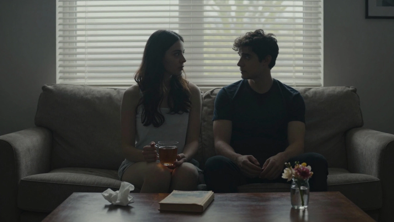 Two people sit side by side at dawn, half-dressed, sharing quiet companionship in a simple apartment.